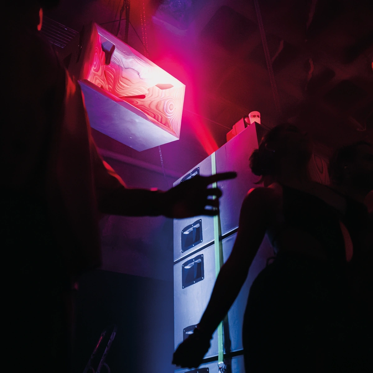 A Cohérence 15 above a stack of Impact 21 in a club, lit red