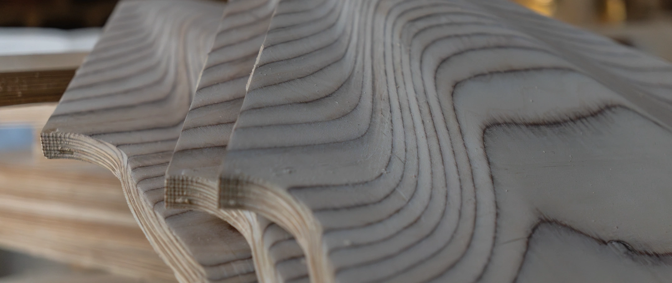 Birch horn parts on the workshop bench, the layers of the ply drawn as lines by the machining